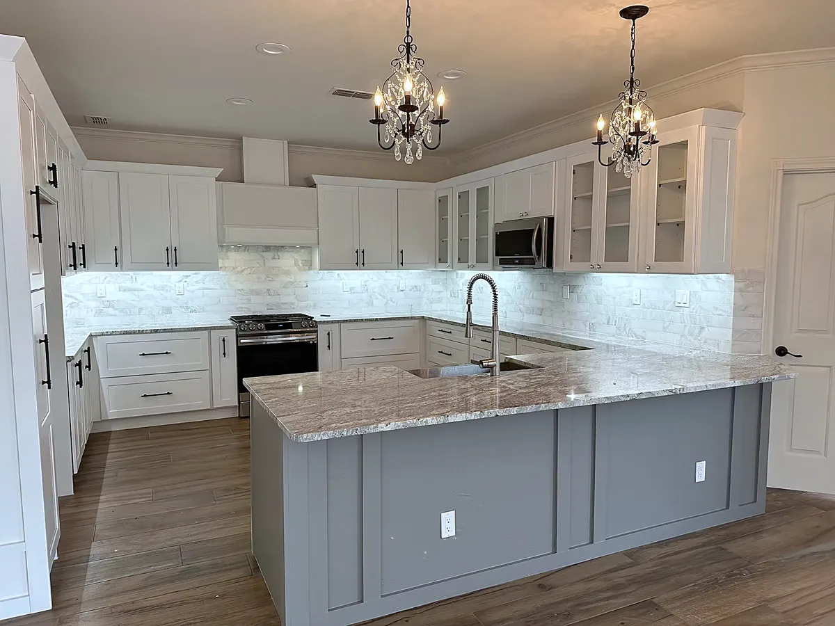 Chandelier-lit kitchen with a marble backsplash